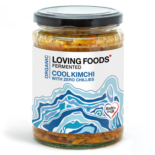 Organic Cool Kimchi jar from Loving Foods with vibrant fermented vegetables and fresh green cabbage visible inside.