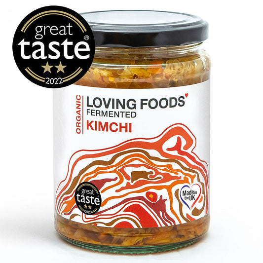 Organic Loving Foods Kimchi in a glass jar with visible fermented vegetables and red pepper flakes on top.