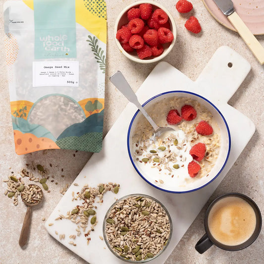 Omega Seed Mix by Whole Food Earth featuring a colorful blend of five nutritious seeds in a natural setting.