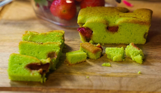 Slice of pandan and raspberry free from cake from The Healthy Cake Company, showing vibrant green pandan layers with fresh raspberries.