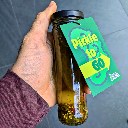 Jar of Pickle to Go from CROOKED PICKLE CO with bright green pickles in a clear container, ready for on-the-go snacking.