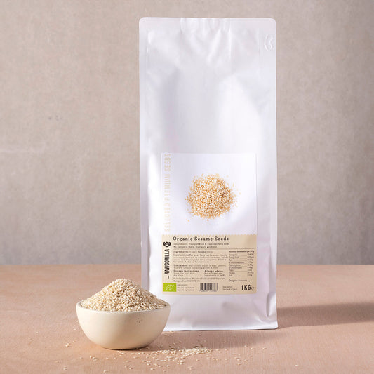 Organic sesame seeds from RAWGORILLA, 1kg pack, showing small tan seeds in a clear jar, perfect for cooking and baking.
