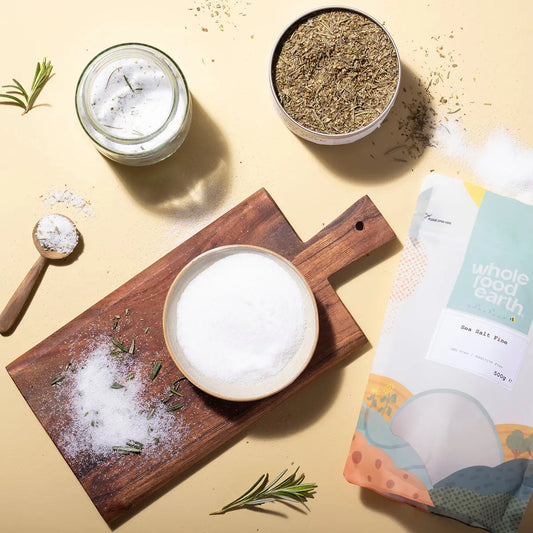 Fine sea salt from Whole Food Earth, shown in a natural setting with salt crystals on a wooden surface.