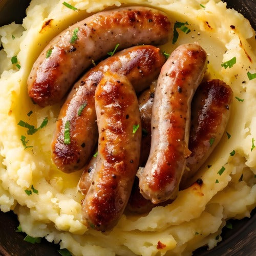 Primrose Herd pork and leek sausages sizzling on a grill, showcasing their juicy, flavorful appearance and fresh ingredients.
