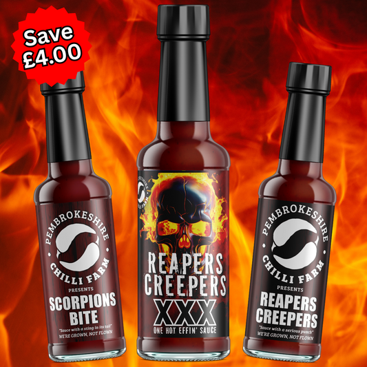 Three bottles of Pembrokeshire Chilli Farm hot sauce in various chili levels, showcasing vibrant labels and colorful sauce inside.