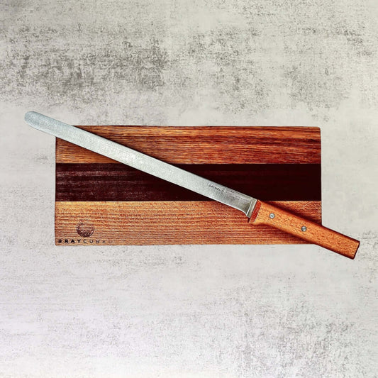 Bray Cured wooden charcuterie board with slicing knife for cheese and meats, displayed on a rustic surface.