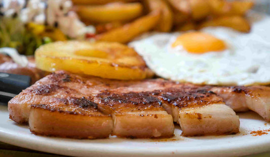 Cooked Primrose Herd pork gammon steaks served on a plate, showing juicy, grilled pork steaks with a golden-brown exterior.