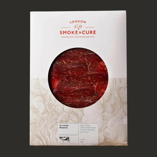 Thin slices of London Smoke & Cure Bresaola, an artisan charcuterie product, arranged on a wooden platter.