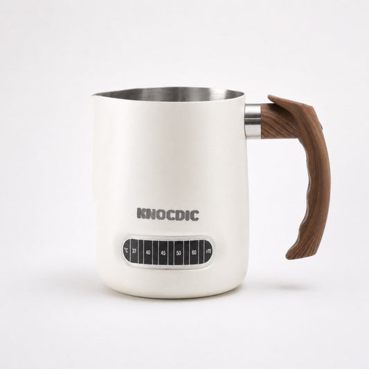 KNOCDIC® milk frothing pitcher with built-in thermometer for precise milk steaming and foaming, ideal for coffee drinks.