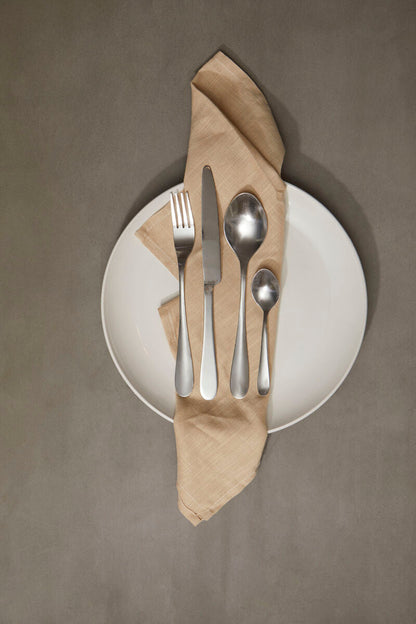 Orsina Gracy 16-piece cutlery set with stainless steel forks, knives, spoons, and teaspoons arranged on a modern table.