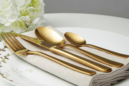 Orsina Glow 16-piece gold cutlery set with forks, knives, spoons, and teaspoons arranged on a table for elegant dining.
