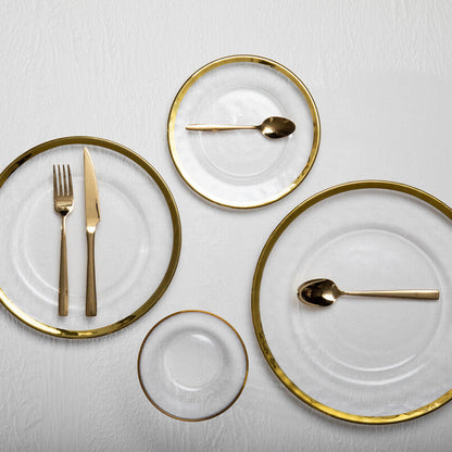 Orsina Glow 16-piece gold cutlery set with sleek forks, knives, and spoons arranged on a dining table.