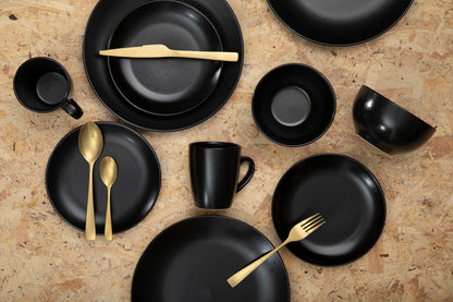 Gold 16-piece cutlery set by Orsina, including forks, knives, spoons, and teaspoons arranged on a table.