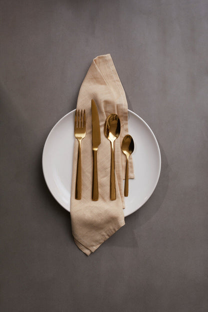 Orsina Glow 16-piece gold cutlery set with forks, knives, spoons, and teaspoons arranged on a white background.