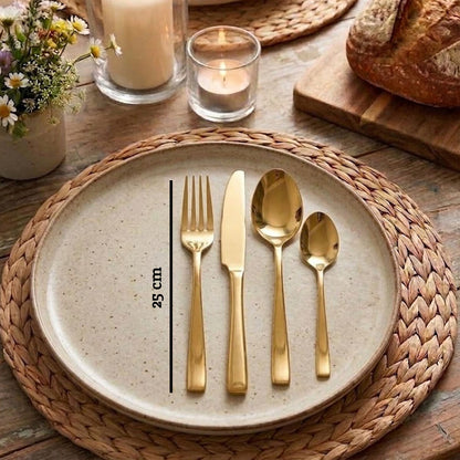 Orsina Glow 16-piece gold cutlery set with sleek forks, knives, spoons, and serving utensils on a neutral background.