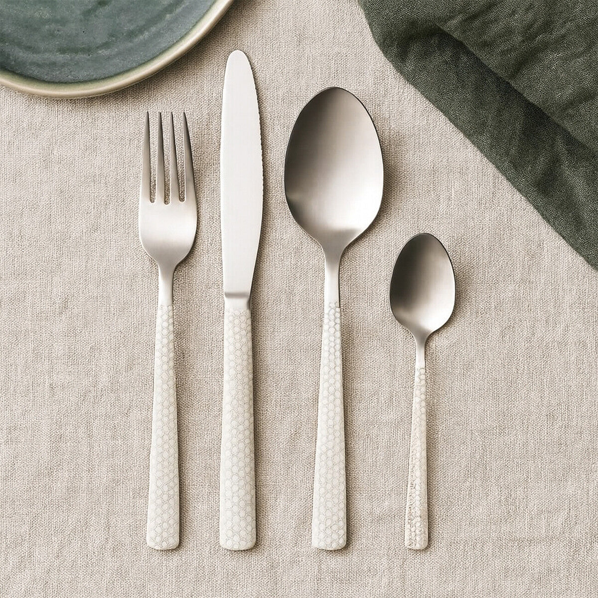 Casablanca 16-piece stainless steel cutlery set by Orsina, including forks, knives, spoons, and teaspoons arranged on a table