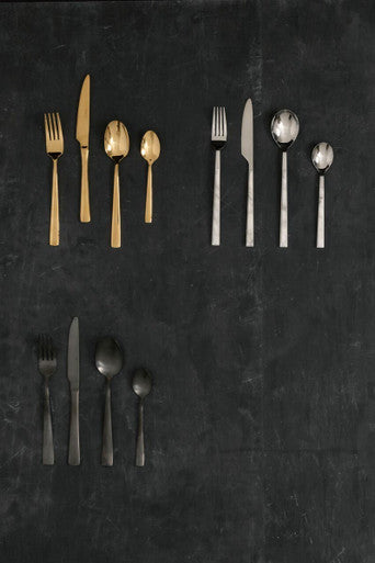 Onyx 16-piece cutlery set by Orsina featuring sleek stainless steel knives, forks, and spoons arranged on a modern dining table.
