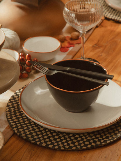 16-piece Onyx cutlery set by Orsina featuring sleek black stainless steel utensils on a neutral background.