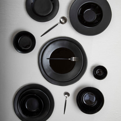 Orsina 16-piece matte silver and black cutlery set with forks, knives, and spoons arranged on a table.