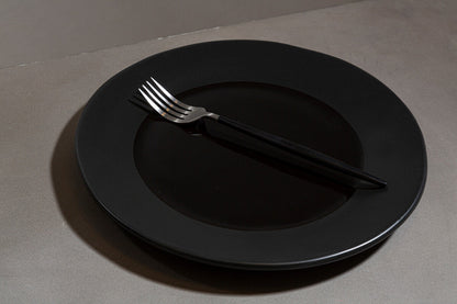 Orsina 16-piece matte silver and black cutlery set with forks, knives, and spoons arranged on a table.