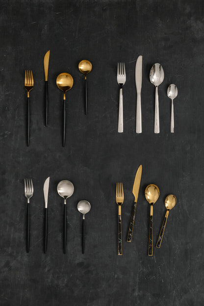 Orsina 16-piece matte silver and black cutlery set with forks, knives, and spoons arranged on a table.
