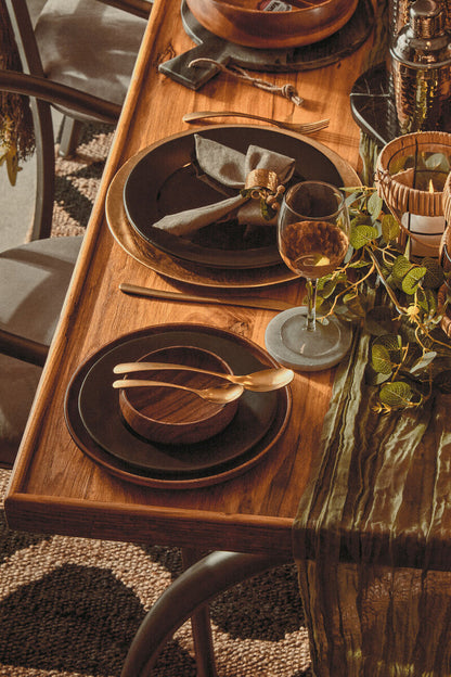 Orsina 16-piece antique gold finish cutlery set with forks, knives, and spoons arranged on a wooden table.