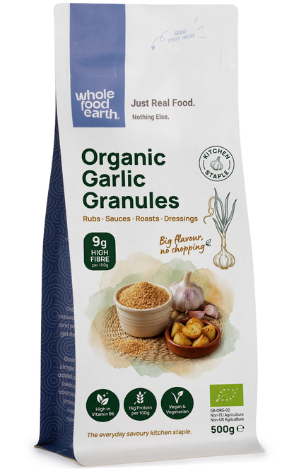 Organic garlic granules from Whole Food Earth, close-up of jar showing fine, dried garlic spice on a neutral background.