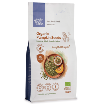 Organic pumpkin seeds from Whole Food Earth, close-up of raw, green pumpkin seeds in a bowl on a rustic wooden surface.