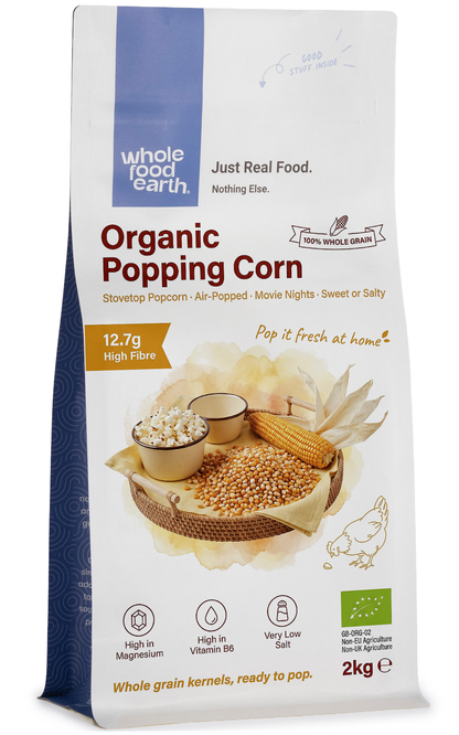 Organic popcorn from Whole Food Earth, displayed in a bowl with popped kernels ready to eat, on a rustic wooden table.