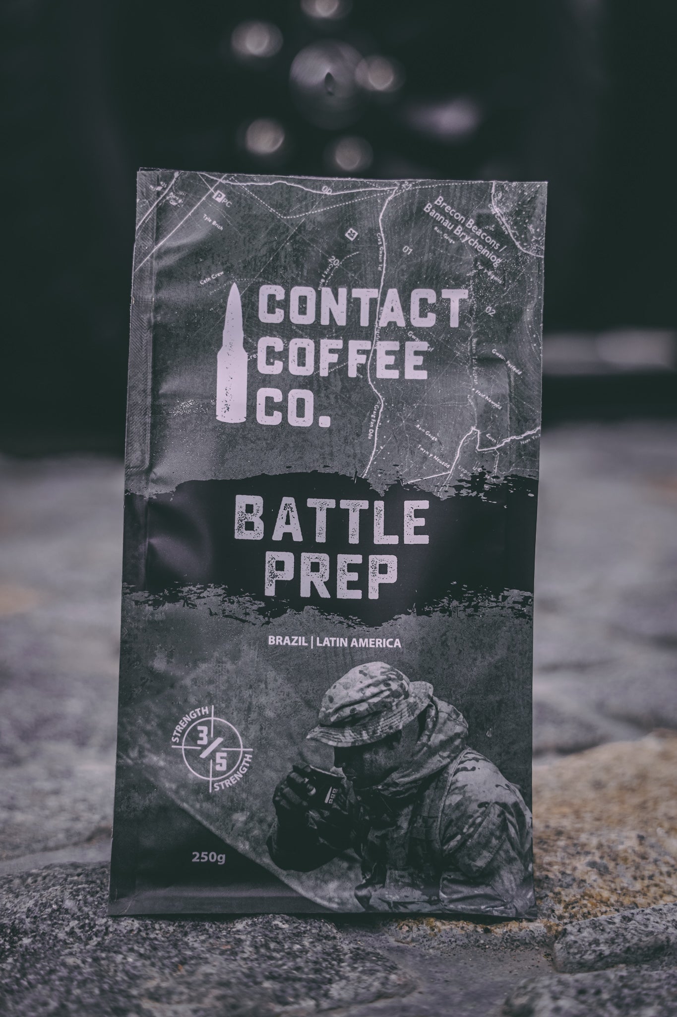A cup of Battle Prep Coffee by Contact Coffee Company Ltd. with a steaming hot coffee beverage in a white mug on a wooden table.