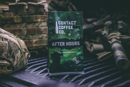 A steaming cup of After Hours Coffee from Contact Coffee Company Ltd. on a wooden table with a cozy background.