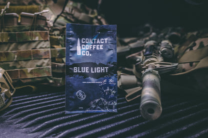 Blue Light Coffee from Contact Coffee Company Ltd., a fresh brewed coffee cup with a blue-themed design on a wooden table.