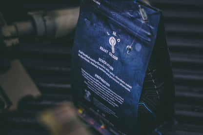 Blue Light Coffee from Contact Coffee Company Ltd., a fresh brewed coffee in a white mug with blue accents on a wooden table.