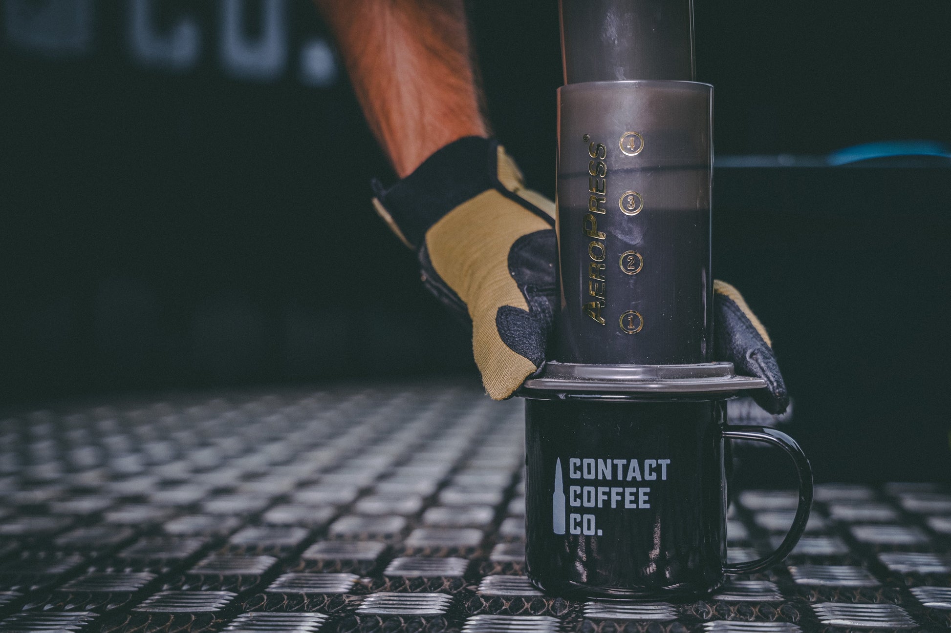 AeroPress Travel Coffee Maker by Contact Coffee Company Ltd. compact gear for brewing coffee on the go, with a sleek black design.
