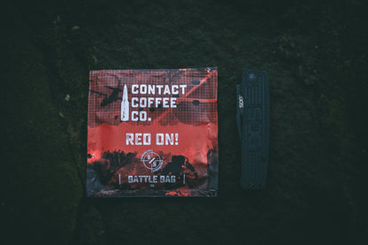Red Single Serve Coffee Bag from Contact Coffee Company Ltd., ready for brewing, with vibrant packaging and coffee grounds visible.