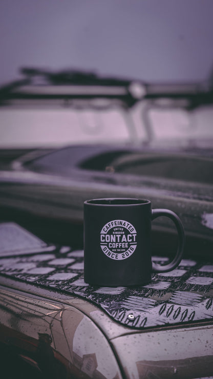 Contact Coffee Co Mug featuring the Bravo gear logo, white ceramic mug with black lettering on a plain background.