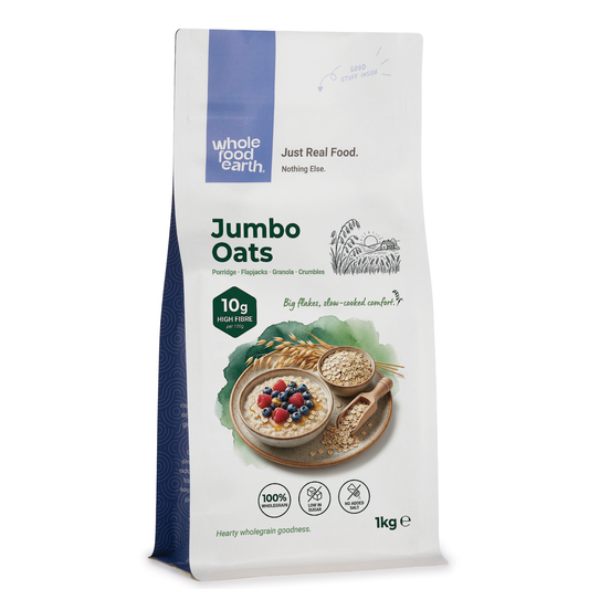 Bowl of Whole Food Earth Jumbo Oats cereal with milk in a white bowl on a wooden table, ready to serve.