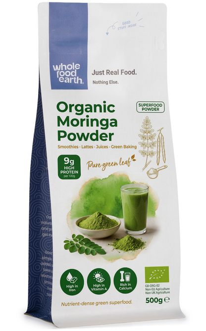 Organic Moringa powder from ArtisanBox in a clear glass jar, showing vibrant green powder with a textured surface.