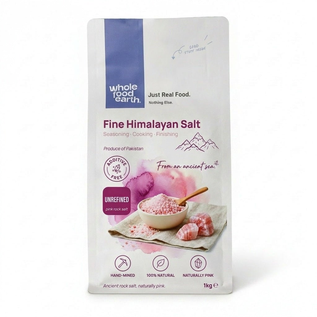 Whole Food Earth Fine Himalayan Salt crystals, natural pink mineral salt for cooking and seasoning, shown in a glass jar.