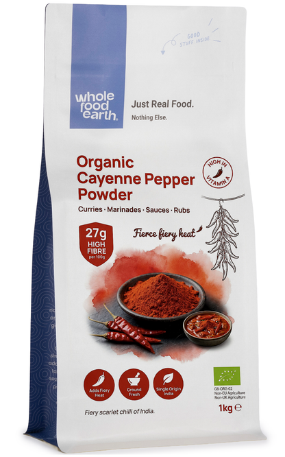 Organic cayenne pepper powder in a clear jar, showcasing bright red spice, from Whole Food Earth, in an herbs and spices collection.