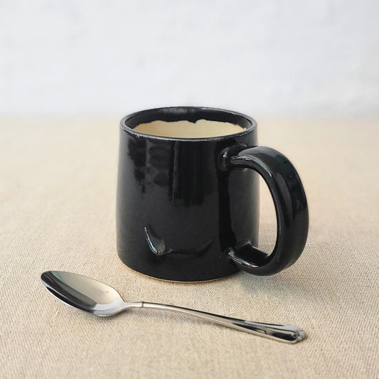 Jet black ceramic standard mug by Katie L Thompson Designs, featuring a sleek, smooth finish and classic shape.