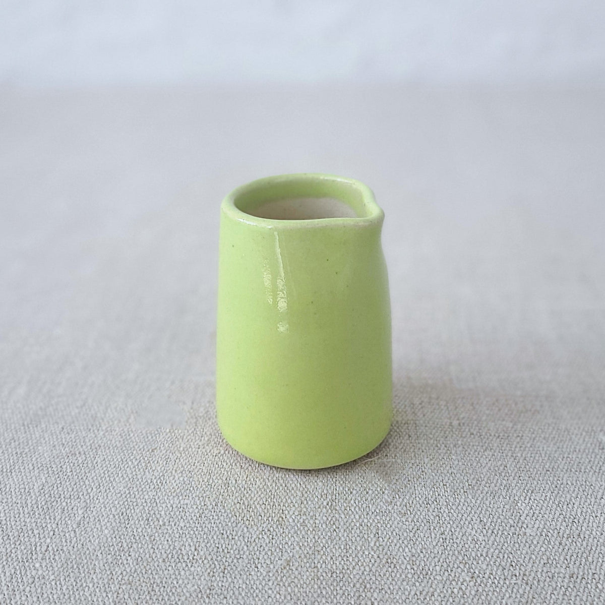 Spring green ceramic mini jug by Katie L Thompson Designs, featuring a classic, smooth rounded shape and small handle.