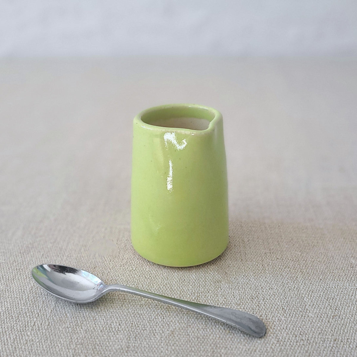 Spring green mini jug by Katie L Thompson Designs featuring a classic, small ceramic jug with a smooth, glossy finish.