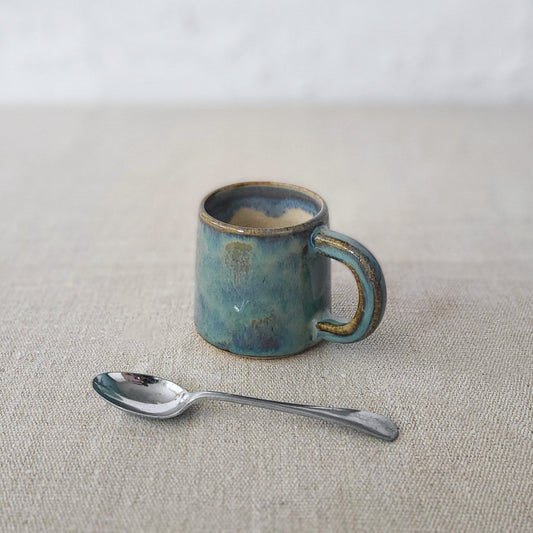 Seafoam blue Katie L Thompson Designs espresso mug with classic shape and handle, ceramic coffee cup on a neutral background.