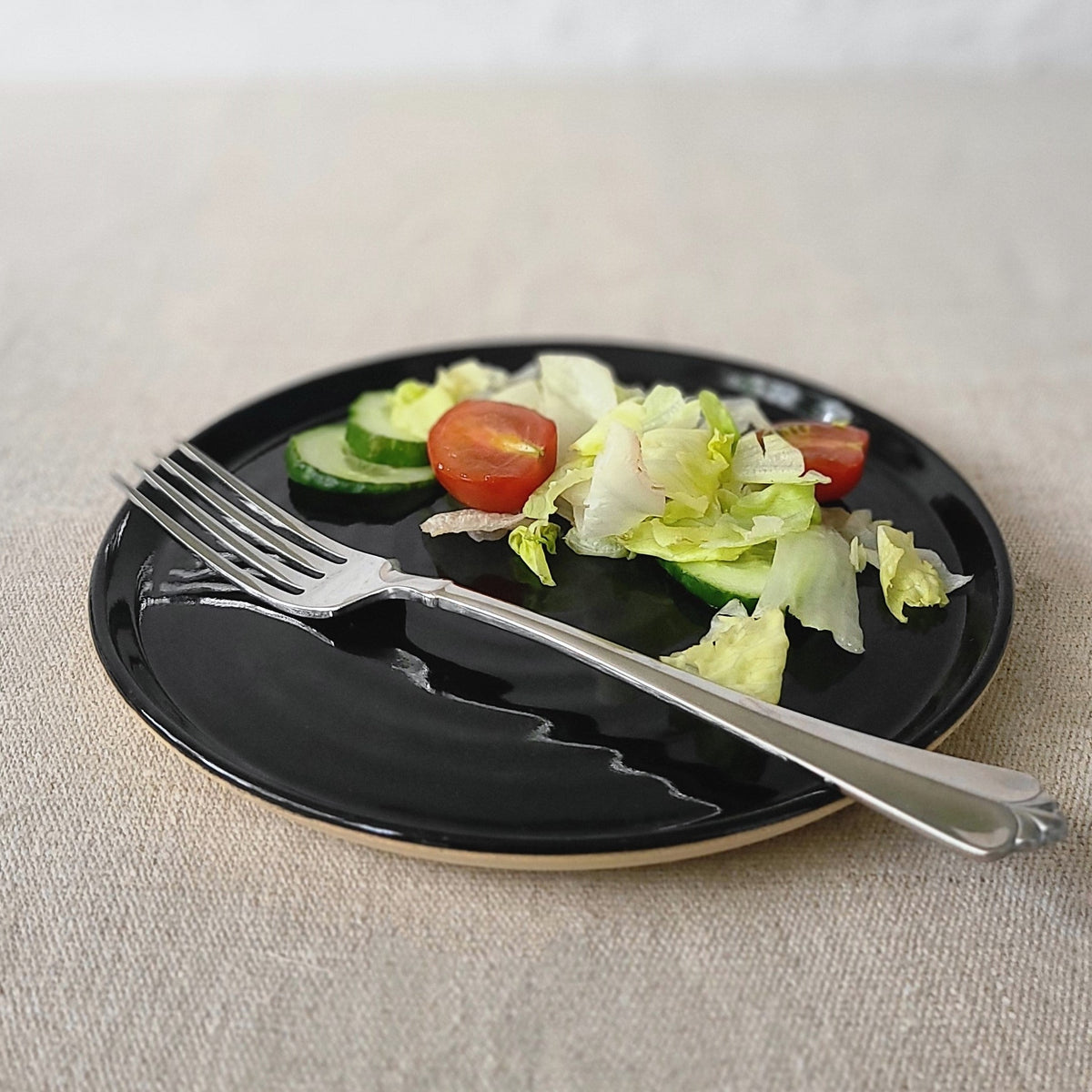 Jet black classic side plate by Katie L Thompson Designs, featuring a smooth round ceramic surface for serving small dishes.