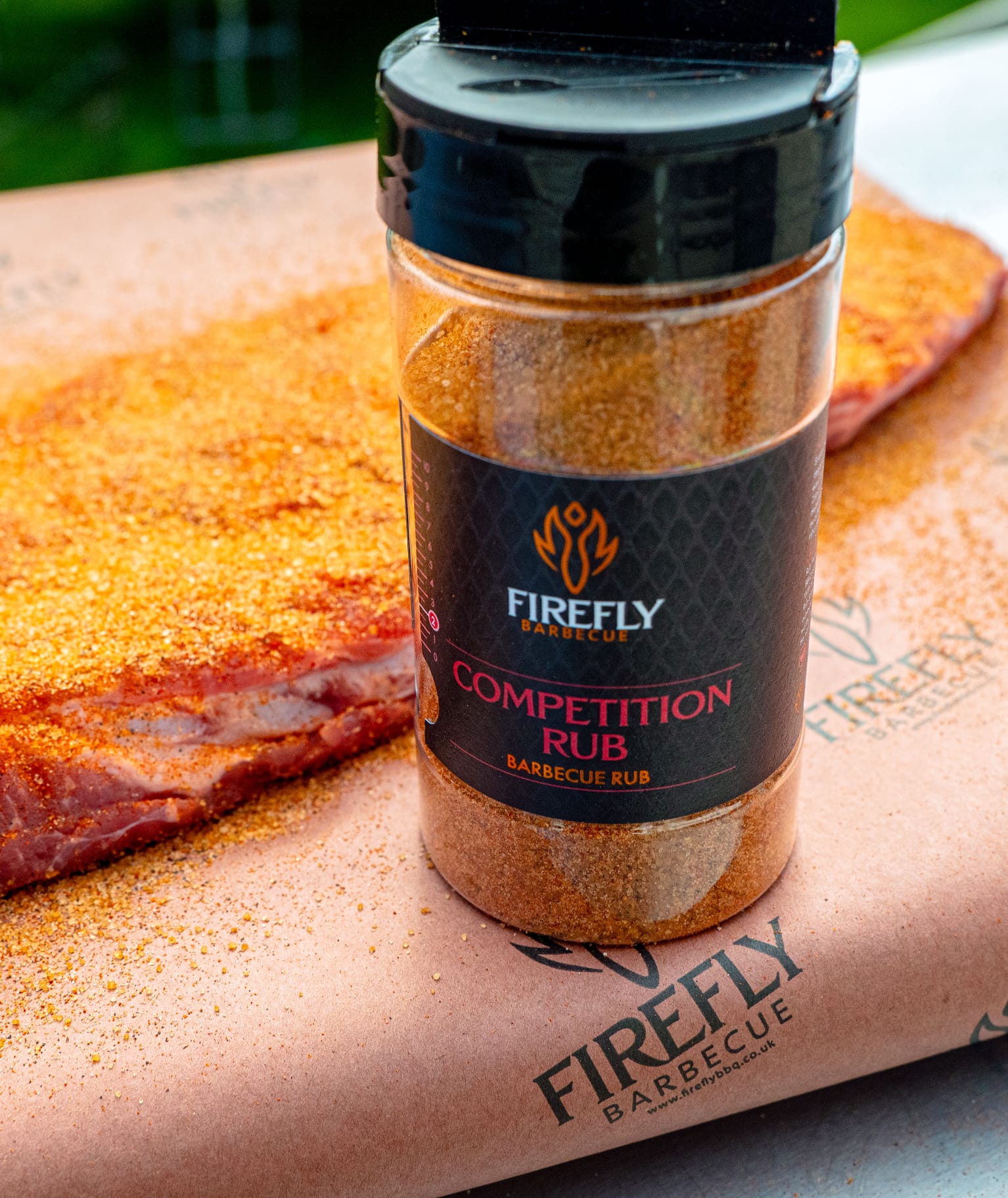 FireFly Barbecue Competition BBQ Rub in a jar, showing the spice blend with a focus on the textured seasoning and label.