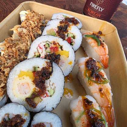 FireFly Barbecue Korean Chilli Crunch spicy hot sauce in a clear glass bottle with a red label, showing bright chili flakes inside.