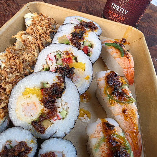 FireFly Barbecue Korean Chilli Crunch spicy hot sauce in a clear glass bottle with a red label, showing bright chili flakes inside.