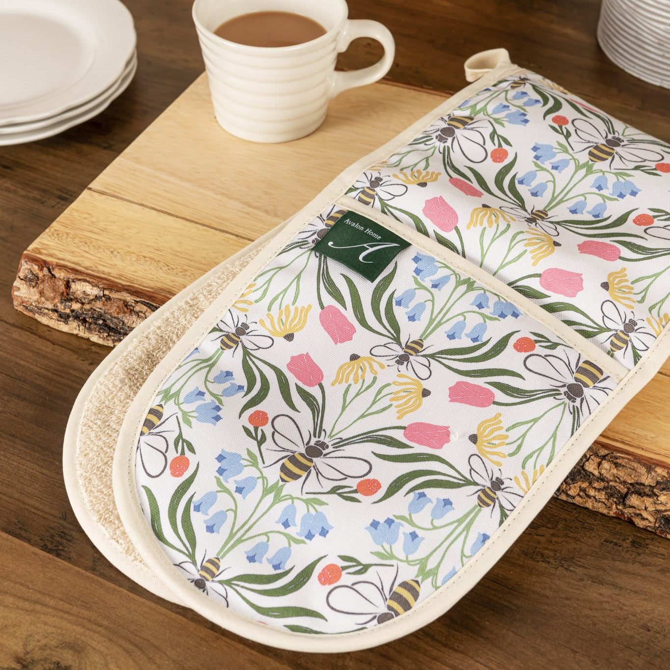 Pair of Avalon Home UK British Bees oven gloves with bee pattern, heat-resistant fabric, shown on a worktop.