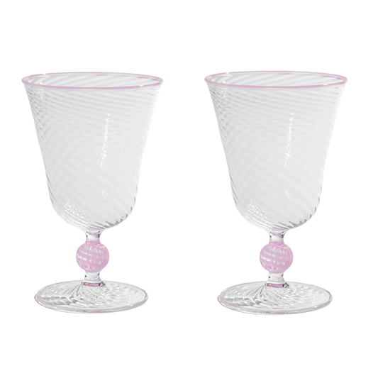 Two pink Dido Venetian wine glasses by domenicamarland with elegant, curved glass design, set against a neutral background.